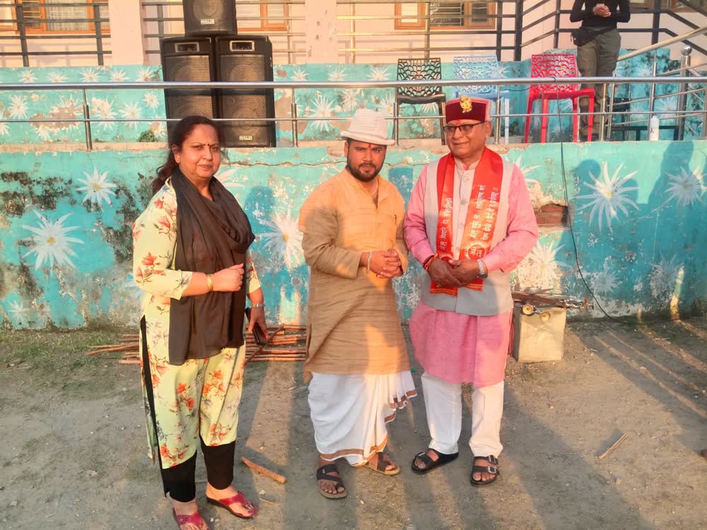 Three people posing together at an evening community programme