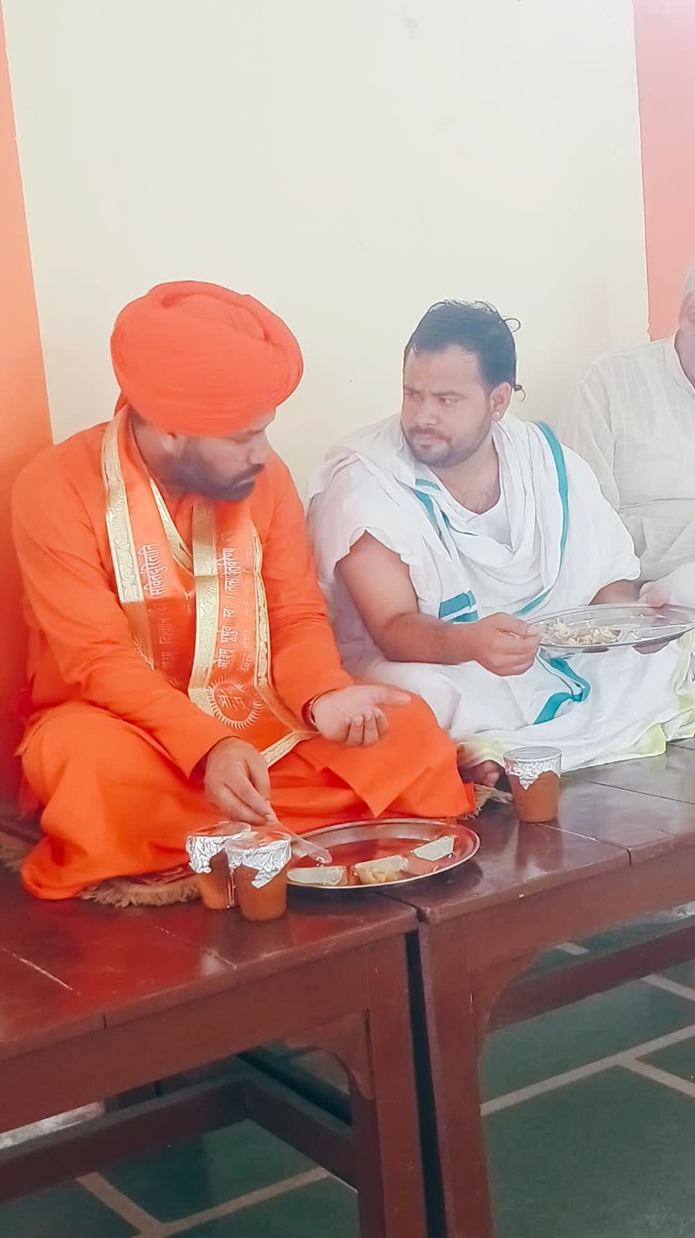 Attendees sharing prasad at a programme